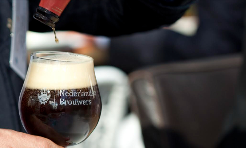 Glas met het logo van de Nederlandse Brouwers wordt ingeschonken met bockbier